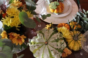 Calda tavola autunnale con zucchette ornamentali